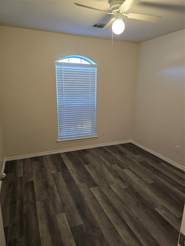 unfurnished room with dark wood-type flooring, visible vents, baseboards, and a ceiling fan