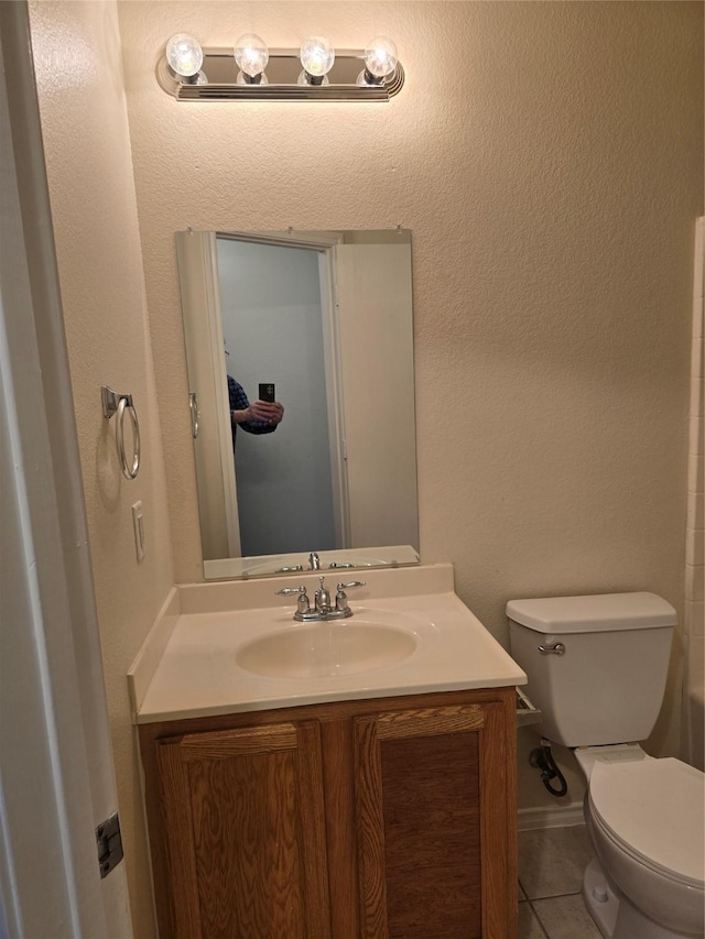 bathroom featuring toilet, vanity, and tile patterned floors