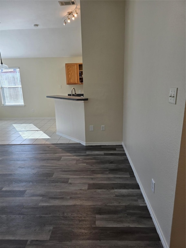 interior space featuring baseboards, visible vents, and dark wood finished floors