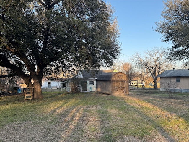 view of yard with a barn, an outdoor structure, and fence