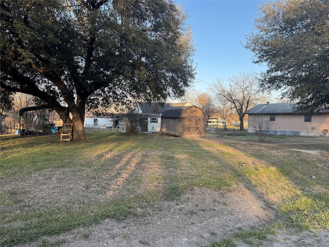 view of yard featuring an outbuilding, fence, and a barn