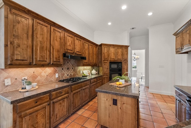 kitchen featuring visible vents, decorative backsplash, dark countertops, under cabinet range hood, and black appliances