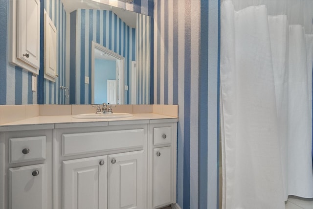 full bath featuring vanity and wallpapered walls