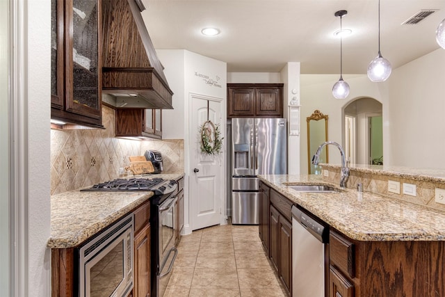 1005 Brendan Dr, Little Elm, TX 75068 - kitchen with stainless steel appliances, custom range hood, a sink, and backsplash