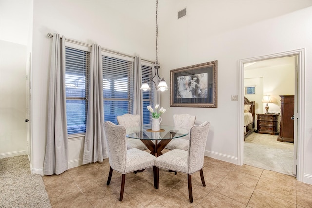 dining area featuring light tile patterned flooring, a notable chandelier, light carpet, visible vents, and baseboards