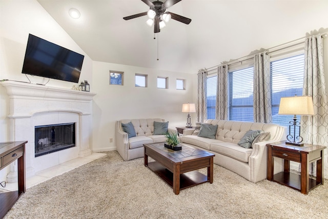 living area with lofted ceiling, ceiling fan, a tile fireplace, carpet floors, and baseboards