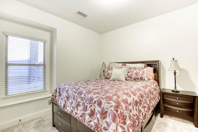 bedroom featuring baseboards, visible vents, and light colored carpet