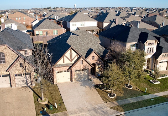 view of front of property featuring driveway, a garage, a residential view, and roof with shingles