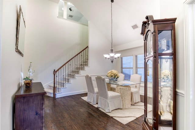 dining area with baseboards, visible vents, wood finished floors, stairs, and a chandelier