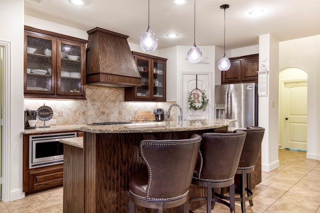 1005 Brendan Dr, Little Elm, TX 75068 - kitchen featuring stainless steel appliances, premium range hood, dark brown cabinetry, decorative backsplash, and recessed lighting