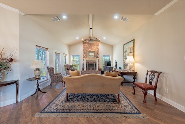 living area with a brick fireplace, wood finished floors, and visible vents