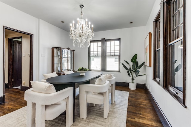 dining room featuring a notable chandelier, wood finished floors, and baseboards