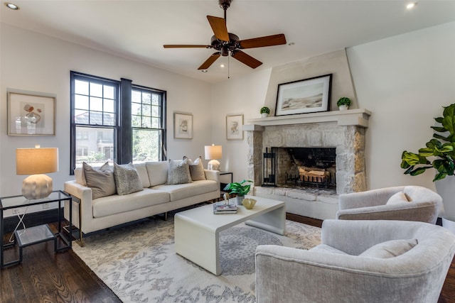 living area with a stone fireplace, recessed lighting, ceiling fan, and wood finished floors