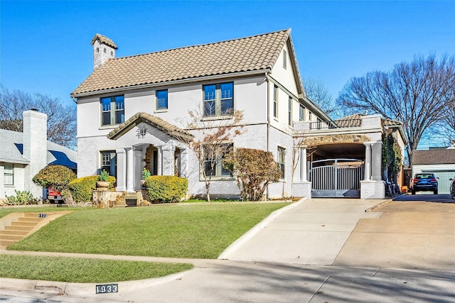 view of front of house featuring a tile roof, a front yard, and a gate