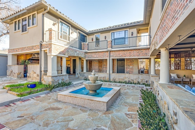 back of house featuring brick siding, a patio area, and stucco siding