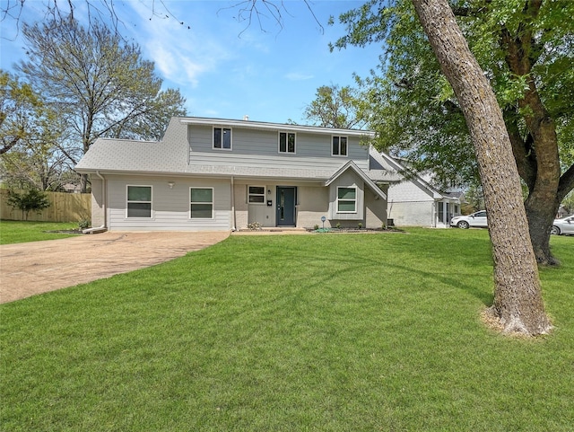 view of front of house featuring a front yard, roof with shingles, and fence