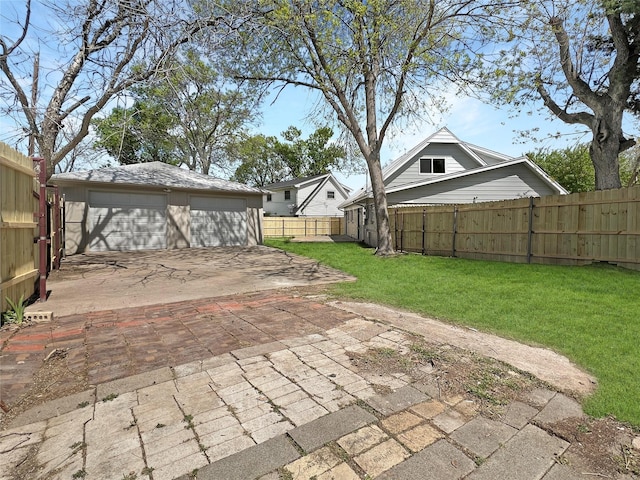 exterior space featuring a garage, fence, and an outbuilding