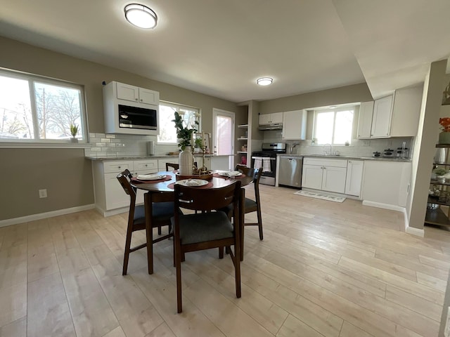 dining area featuring light wood-type flooring and baseboards