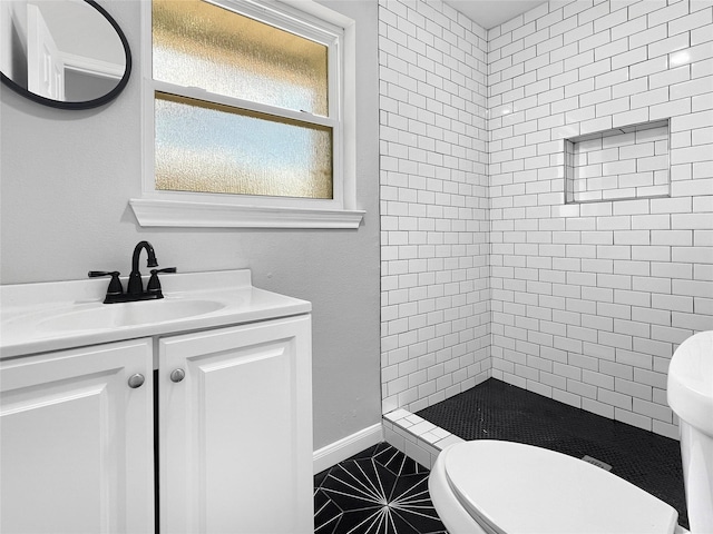 full bath with toilet, a stall shower, vanity, baseboards, and tile patterned floors