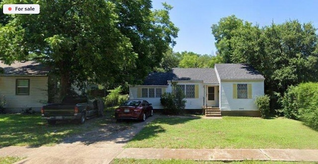 view of front of property featuring entry steps, concrete driveway, and a front yard