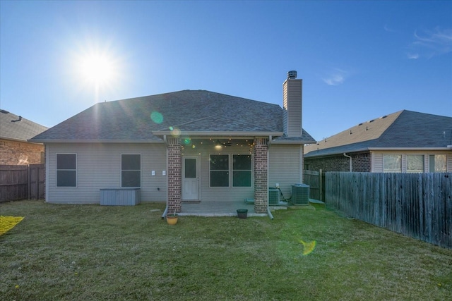 rear view of house featuring a patio area, a fenced backyard, cooling unit, and a yard