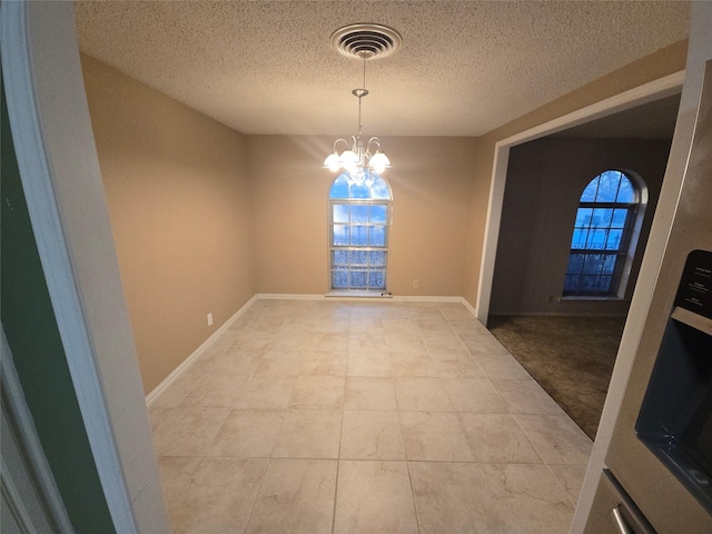 interior space with baseboards, a textured ceiling, visible vents, and an inviting chandelier