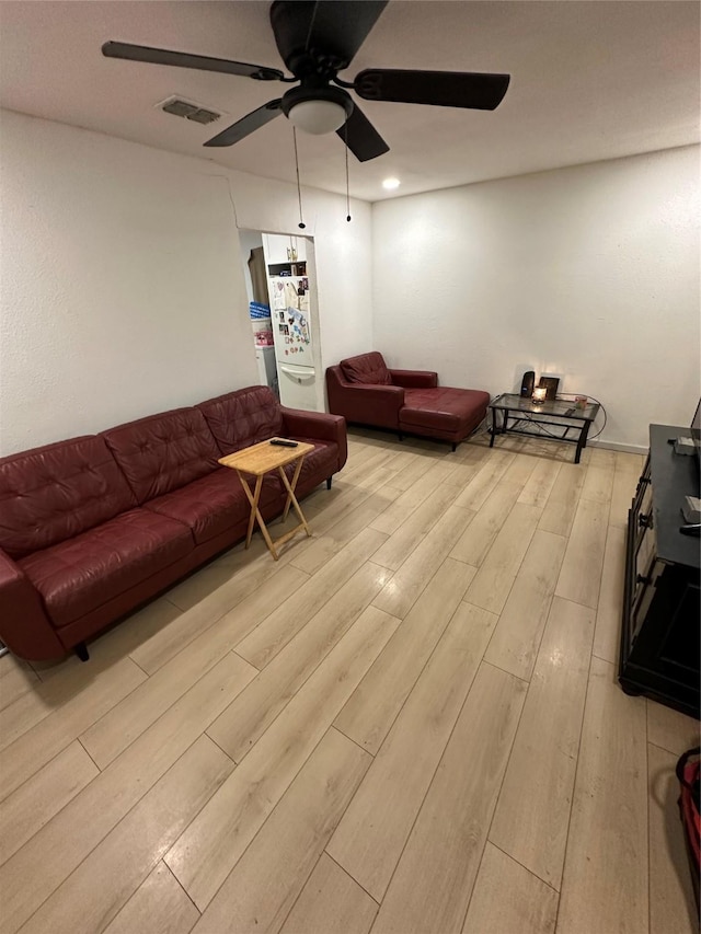 living area with ceiling fan, light wood-type flooring, and visible vents