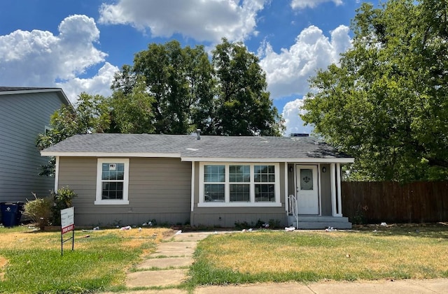 view of front of house with a front yard and fence