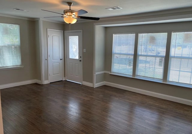 foyer with crown molding, dark wood-style flooring, visible vents, and baseboards