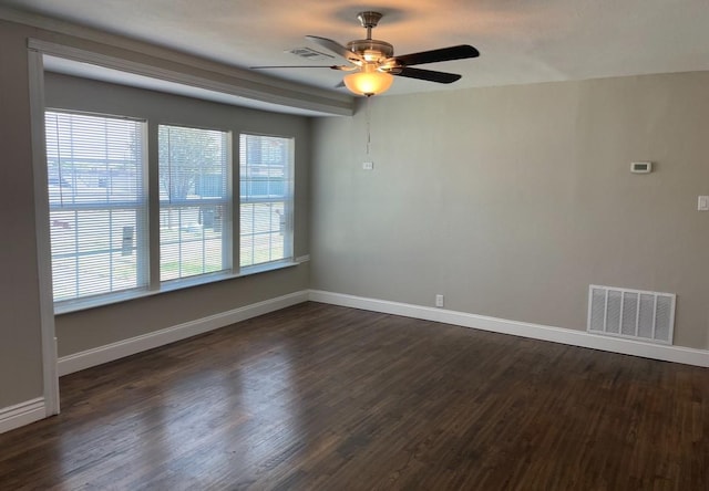 unfurnished room featuring dark wood-type flooring, a ceiling fan, visible vents, and baseboards