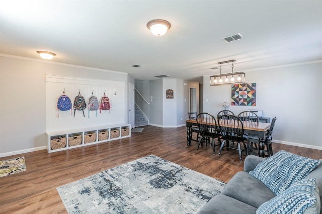 dining room with wood finished floors, visible vents, baseboards, and stairs