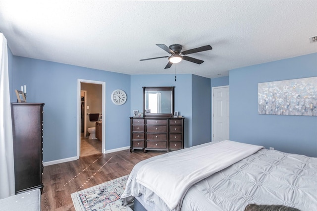 bedroom with visible vents, dark wood-type flooring, ceiling fan, a textured ceiling, and baseboards