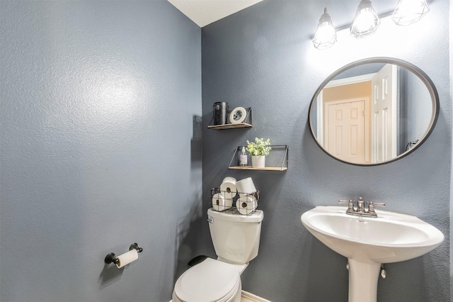 bathroom with toilet and a textured wall