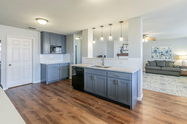 kitchen with visible vents, dishwasher, stainless steel microwave, light countertops, and a sink