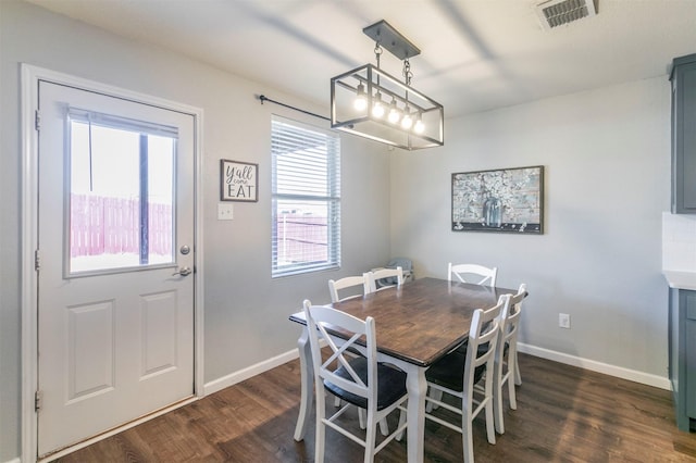 dining area featuring dark wood-style floors, visible vents, and baseboards