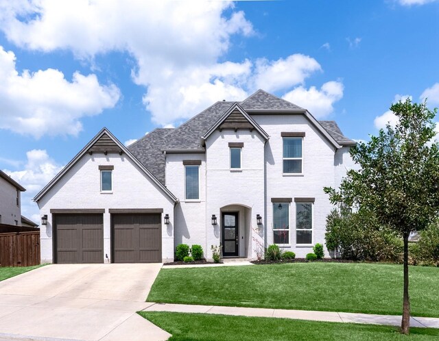 view of front of property featuring concrete driveway, brick siding, fence, and a front yard