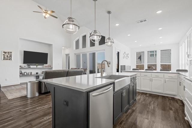 kitchen with open floor plan, white cabinetry, dishwasher, and dark wood-style flooring