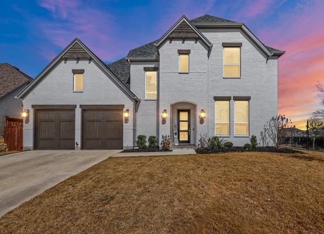 view of front of house featuring concrete driveway, a front lawn, fence, and brick siding