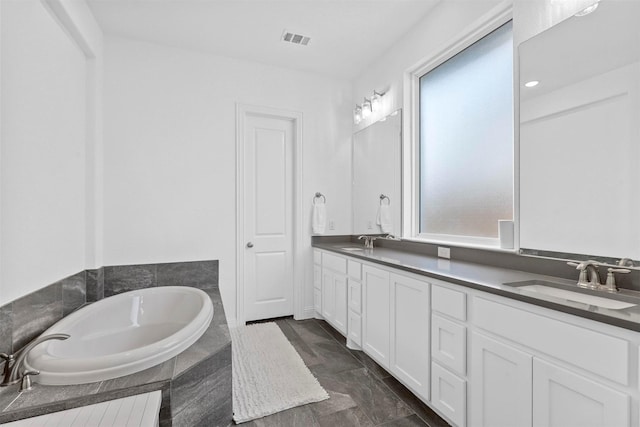 full bath with a bath, double vanity, a sink, and visible vents