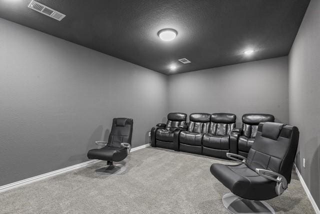 carpeted cinema featuring visible vents and baseboards