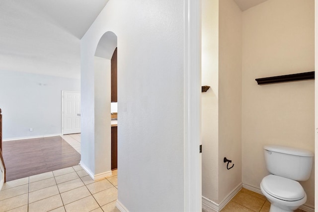 bathroom featuring baseboards, toilet, and tile patterned floors