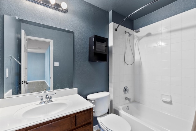 full bath with toilet, vanity, shower / washtub combination, and a textured wall