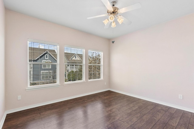 empty room with dark wood-style floors, baseboards, and a ceiling fan