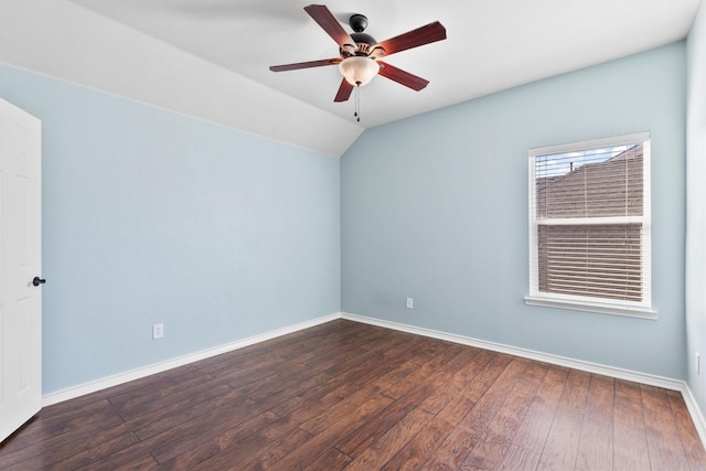 spare room with lofted ceiling, ceiling fan, dark wood-style flooring, and baseboards