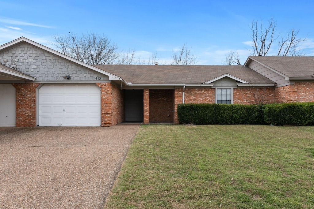 ranch-style house with a garage, a front yard, brick siding, and driveway