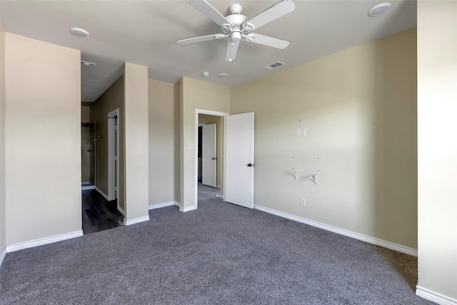 unfurnished bedroom with visible vents, dark carpet, and baseboards