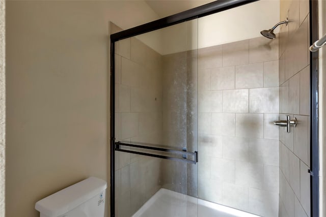 full bath with toilet and a tile shower
