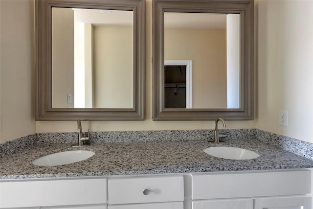 full bathroom with double vanity and a sink