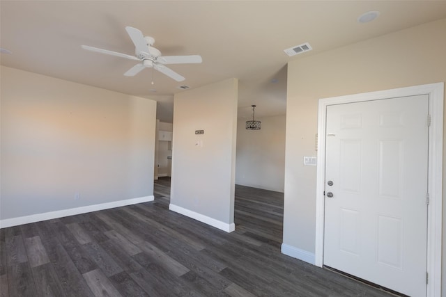 unfurnished room with ceiling fan, dark wood finished floors, visible vents, and baseboards