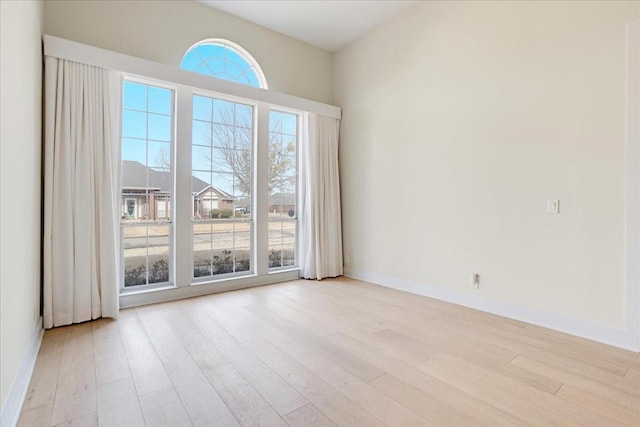 spare room with light wood-style flooring and baseboards